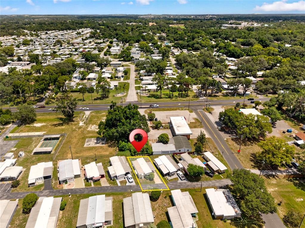 An aerial view shows a mobile home community with a highlighted property and surrounding trees — 37433 RAY DRIVE, ZEPHYRHILLS, FL