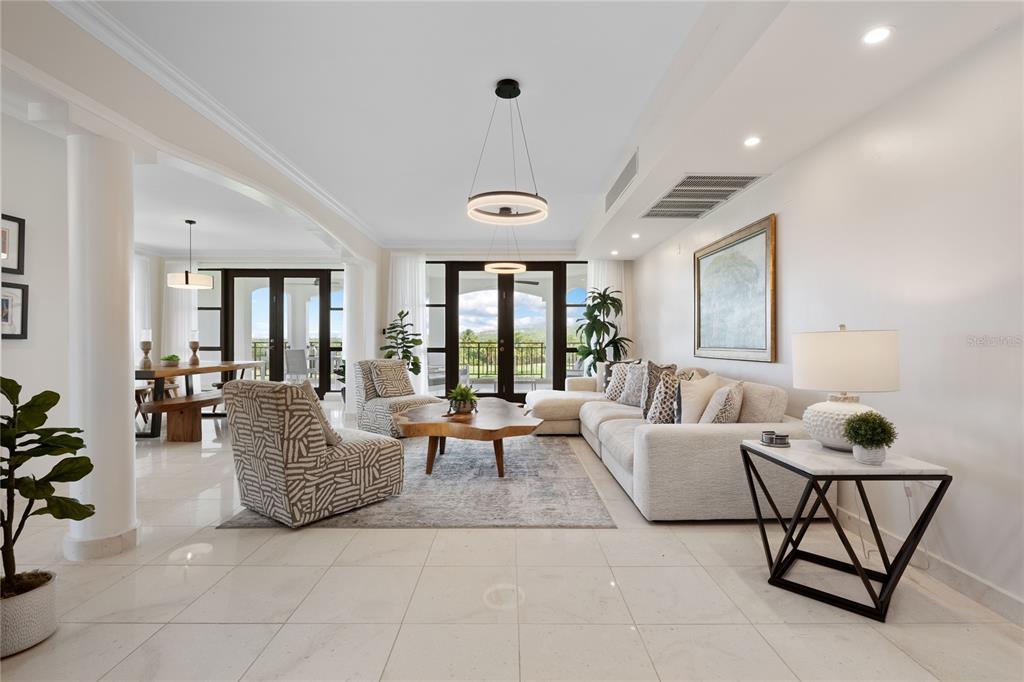 A bright, open-concept living room features tile flooring, a sectional sofa, and a dining area — 406 COCO BEACH BVL UNIT 401A, RIO GRANDE, PR