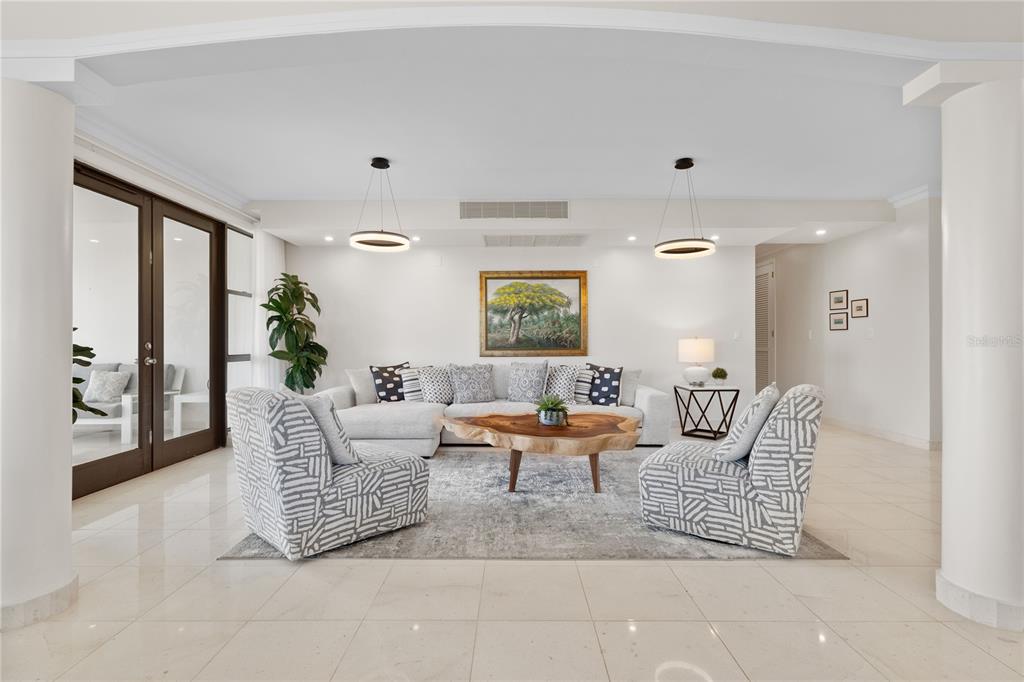 A living room features a sectional sofa, two patterned armchairs, and a live-edge wood coffee table — 406 COCO BEACH BVL UNIT 401A, RIO GRANDE, PR