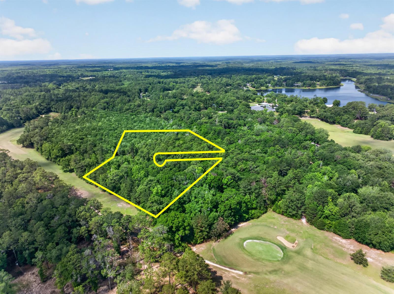 An aerial view shows a wooded lot outlined in yellow adjacent to a golf course — 2744-2748 Little John Lane, FL 32425, FL
