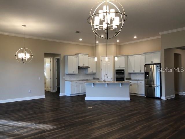 A kitchen with white cabinets, a center island, and dark wood flooring — 3181 AGOSTINO TERRACE, KISSIMMEE, FL