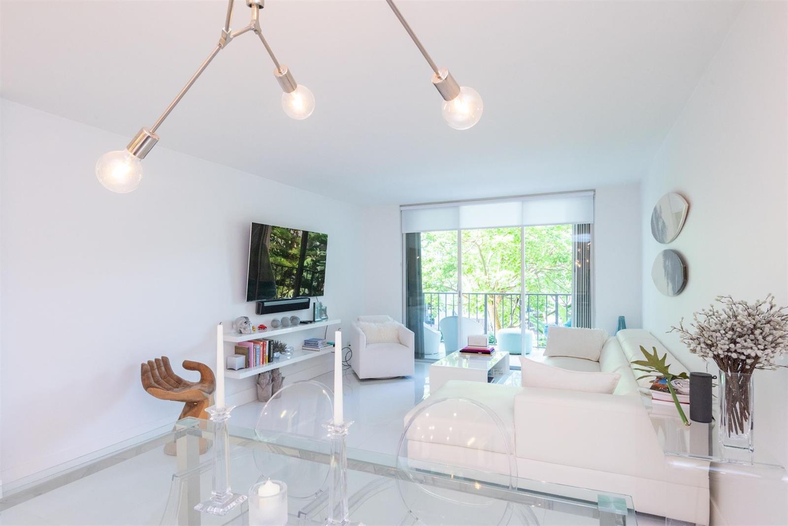 A bright living room features white furniture, a glass dining table, and a balcony view — 3581 S Ocean Boulevard # 2b, Palm Beach FL 33480, PALM BEACH, FL
