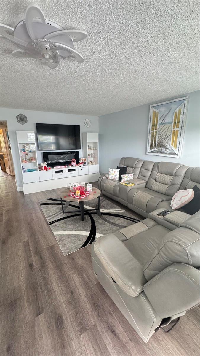 A living room features a grey sectional sofa, a coffee table, and a media console — 3021 Ellesmere B # 3021, Deerfield Beach FL 33442, DEERFIELD BEACH, FL