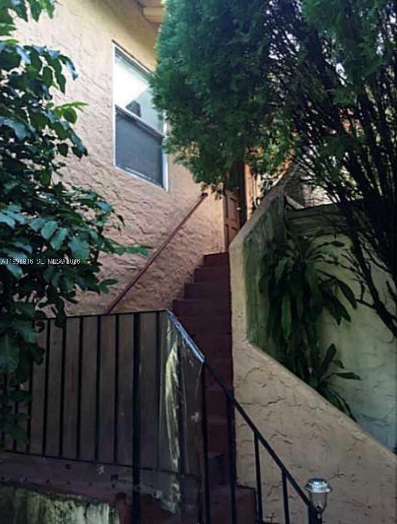 An exterior view shows a set of concrete stairs leading up to a wooden door — 2528 SW 16th St, Miami FL 33145, MIAMI, FL