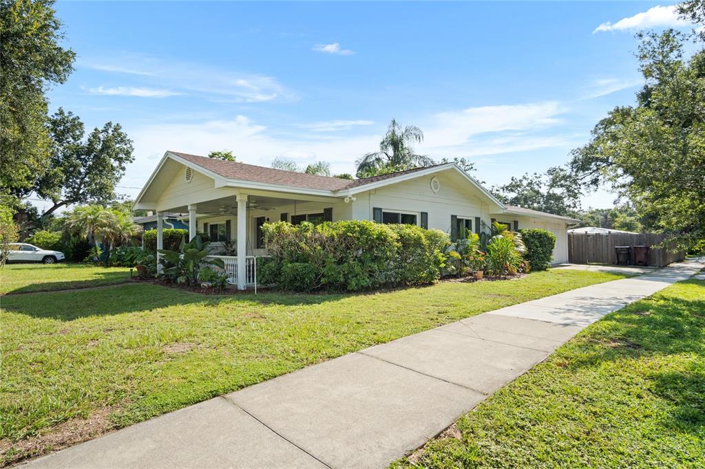 A single-story house with a covered front porch, light siding, and a concrete driveway — 501 MERIDALE AVENUE, ORLANDO, FL