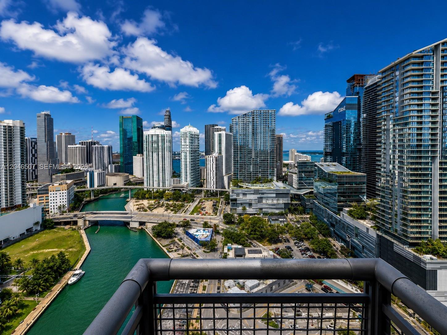 A high-angle view of the Miami skyline and river from a balcony with railings — 690 SW 1st Ct # 3104, Miami FL 33130, MIAMI, FL