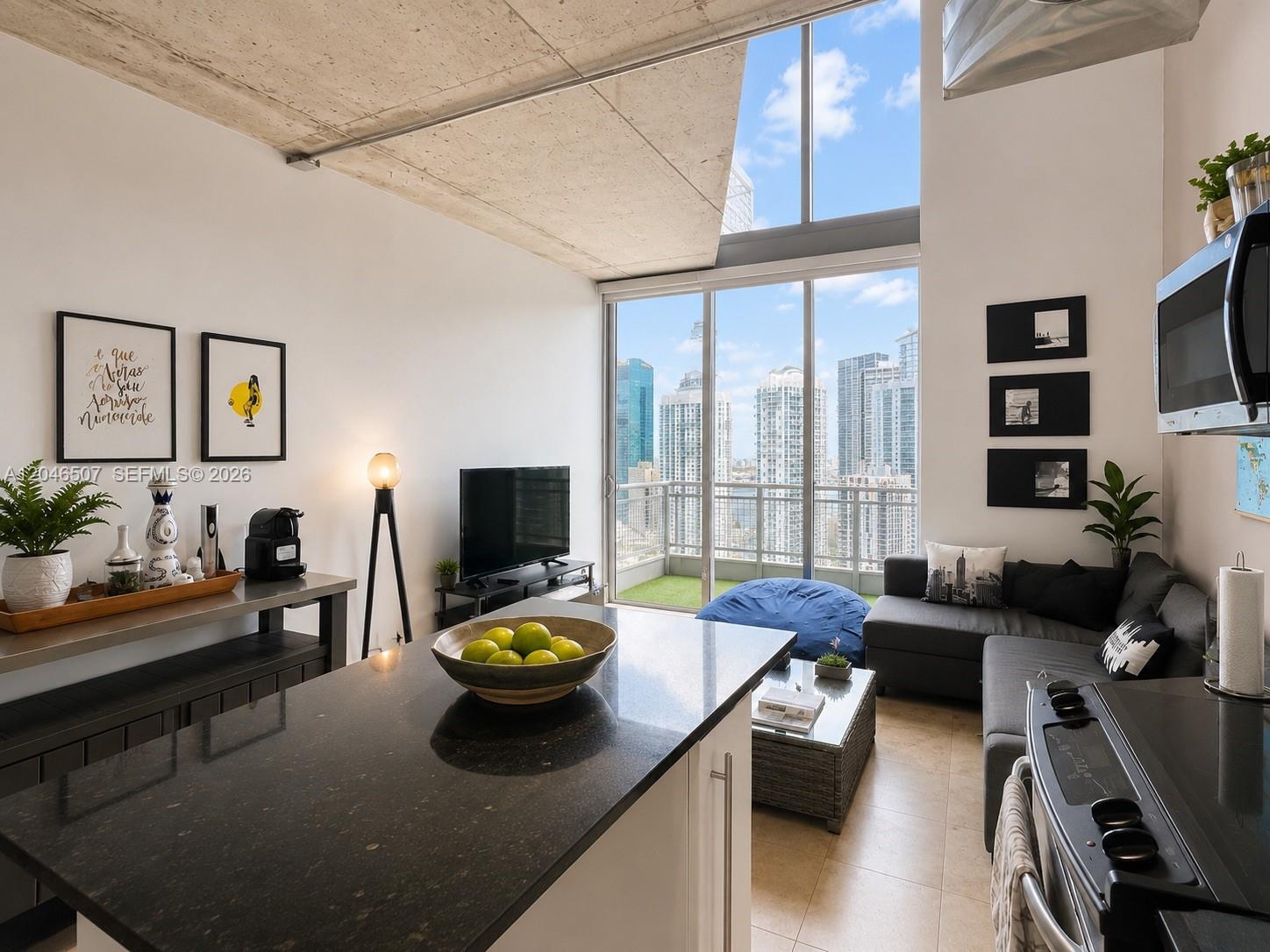 A modern apartment living area with a kitchen island, concrete ceiling, and floor-to-ceiling windows — 690 SW 1st Ct # 3104, Miami FL 33130, MIAMI, FL