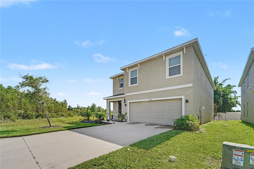 A two-story suburban house with a beige stucco exterior and a two-car garage — 3446 SUNCOAST PLAINS DRIVE, ODESSA, FL