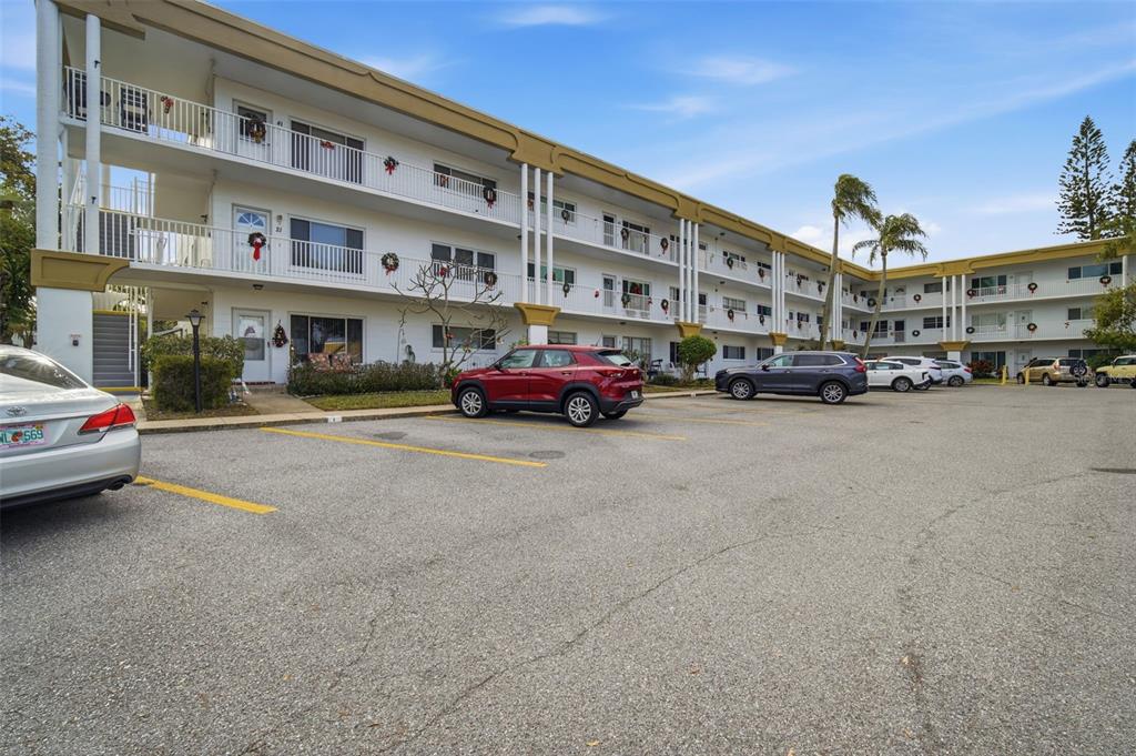 A three-story apartment building with a parking lot in the foreground — 2431 CANADIAN WAY UNIT 47, CLEARWATER, FL