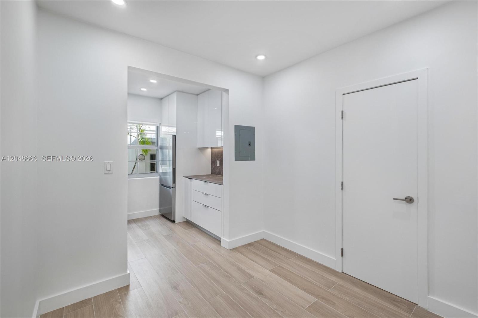 A white kitchen with stainless steel appliances and light wood flooring is visible — 1610 Michigan Ave # 2, Miami Beach FL 33139, MIAMI BEACH, FL