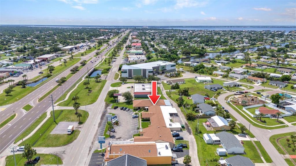 An aerial view shows a commercial building with a brown roof and a parking lot — 3443 TAMIAMI TRAIL UNIT C, PORT CHARLOTTE, FL
