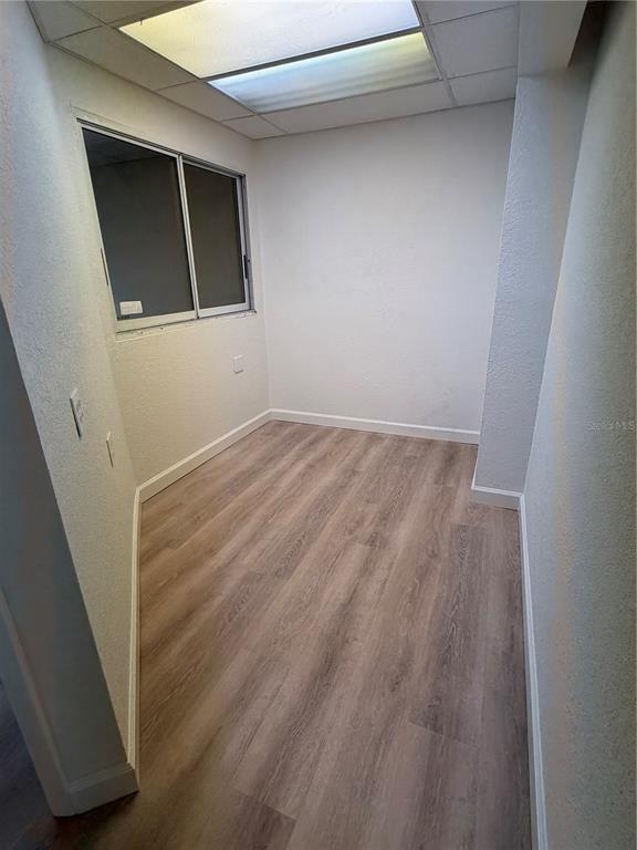 A small, empty room features light wood-look flooring, white walls, and a recessed ceiling light — 3443 TAMIAMI TRAIL UNIT C, PORT CHARLOTTE, FL
