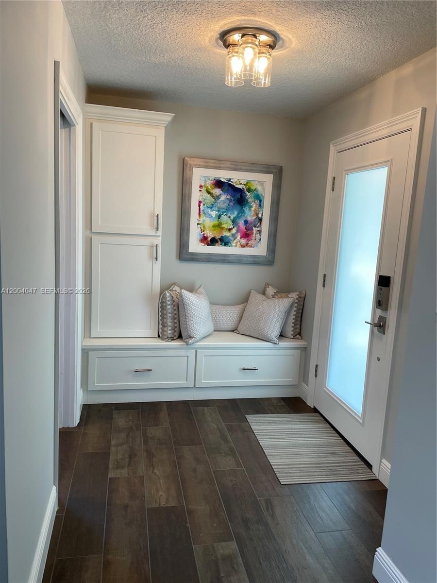 An entryway features a built-in bench with storage drawers, a tall cabinet, and wall art — 126 Ocean PInes Terrace # 126, Jupiter FL 33477, JUPITER, FL