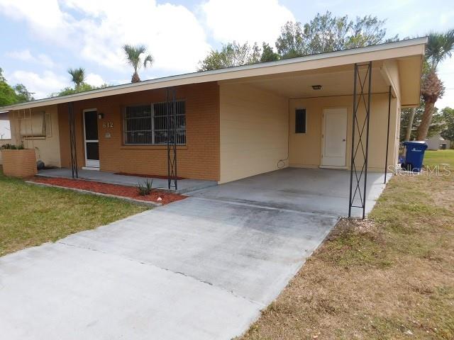 A single-story house with a brick facade, a concrete driveway, and an attached carport — 612 SHAMROCK BOULEVARD, VENICE, FL