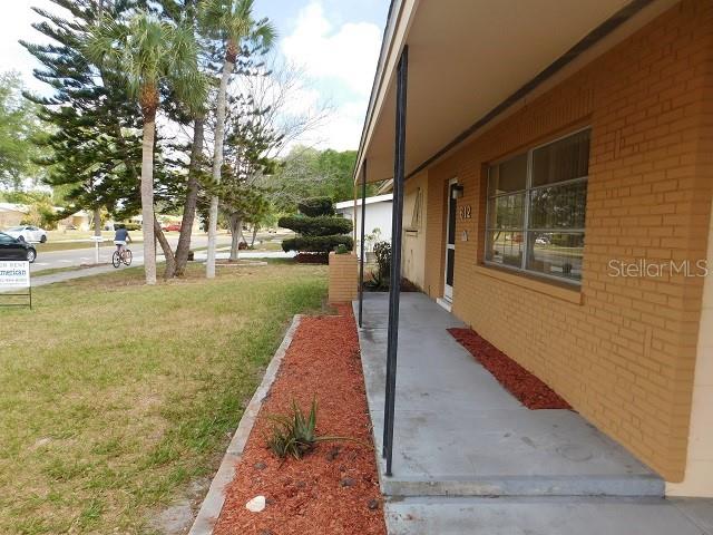 A brick exterior house features a concrete porch and a landscaped bed with red mulch — 612 SHAMROCK BOULEVARD, VENICE, FL