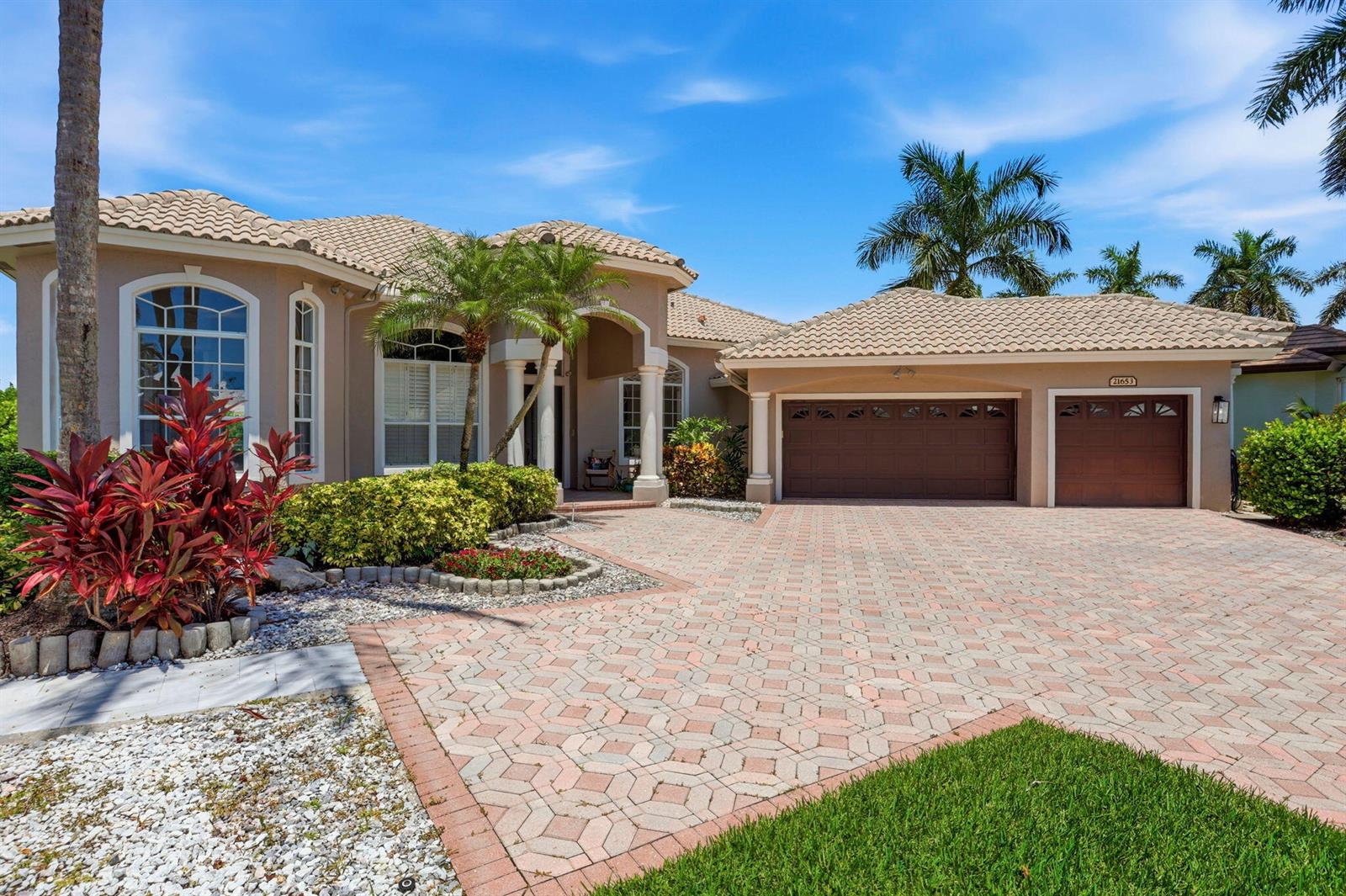 A single-story house with a beige stucco exterior, tile roof, and a paved brick driveway — 21653 Marigot Drive, Boca Raton FL 33428, BOCA RATON, FL