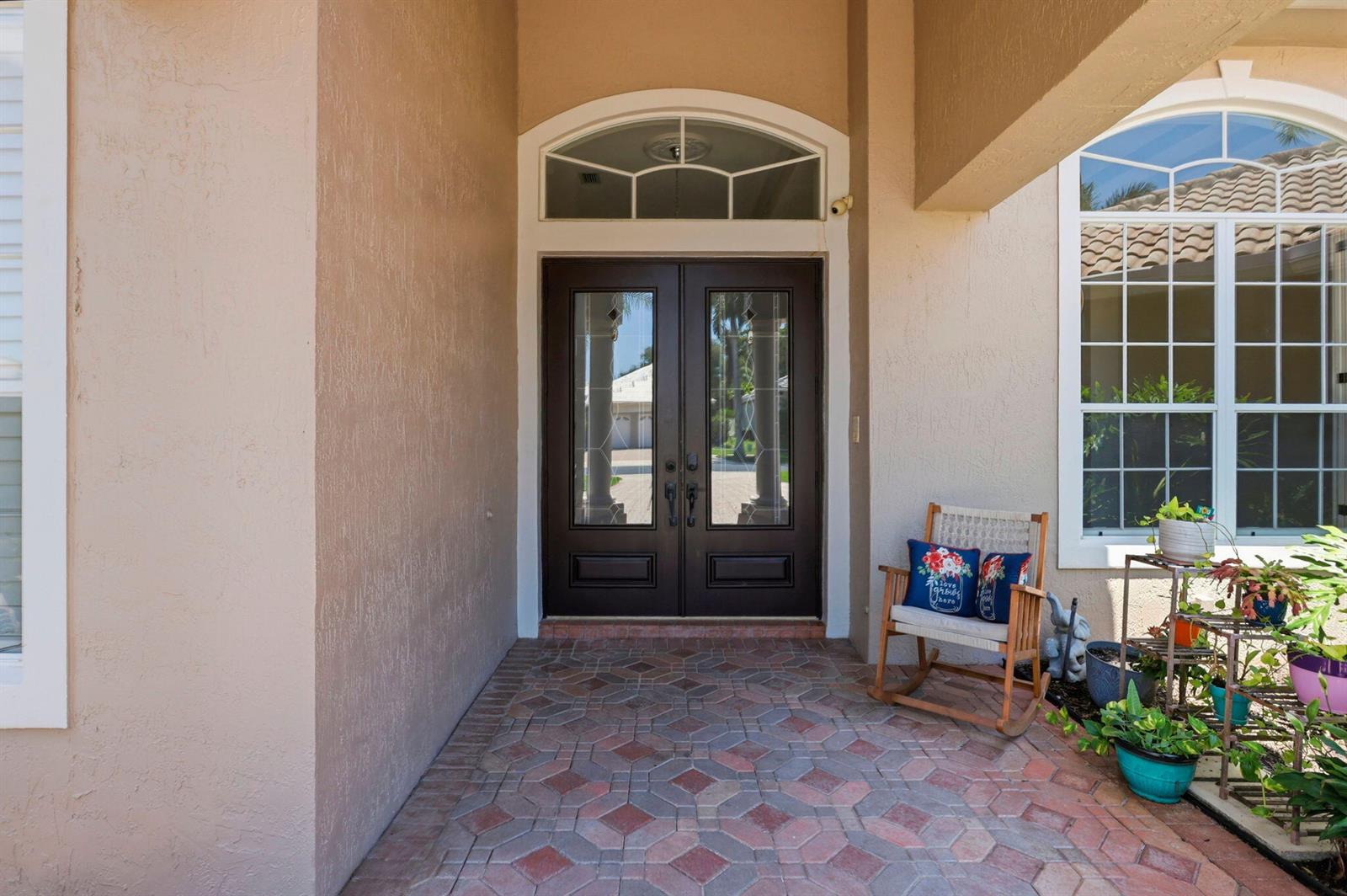 A covered entryway features a double front door, a transom window, and a tiled porch — 21653 Marigot Drive, Boca Raton FL 33428, BOCA RATON, FL