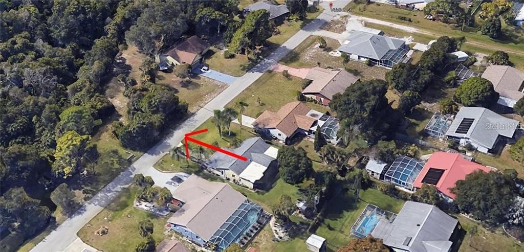 An aerial view of a suburban neighborhood with a red arrow pointing to a house — Lot 39 VIRIDIAN STREET, ENGLEWOOD, FL