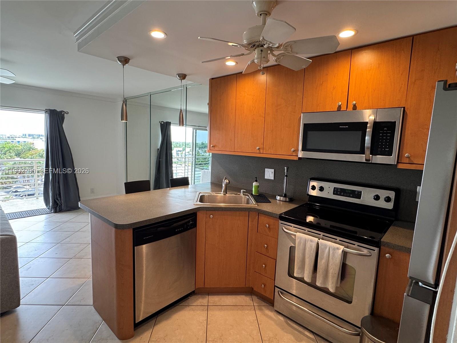 A bathroom features a vanity with a laminate countertop, a toilet, and a tiled tub — FORT LAUDERDALE, FL