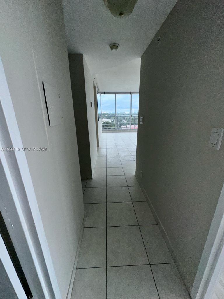 A tiled hallway leads toward a balcony with a view of the surrounding area — 1720 Harrison St # 9A, Hollywood FL 33020, HOLLYWOOD, FL