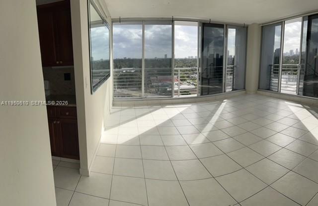 An interior view of a room with white tile floors and floor-to-ceiling windows — 1720 Harrison St # 9A, Hollywood FL 33020, HOLLYWOOD, FL