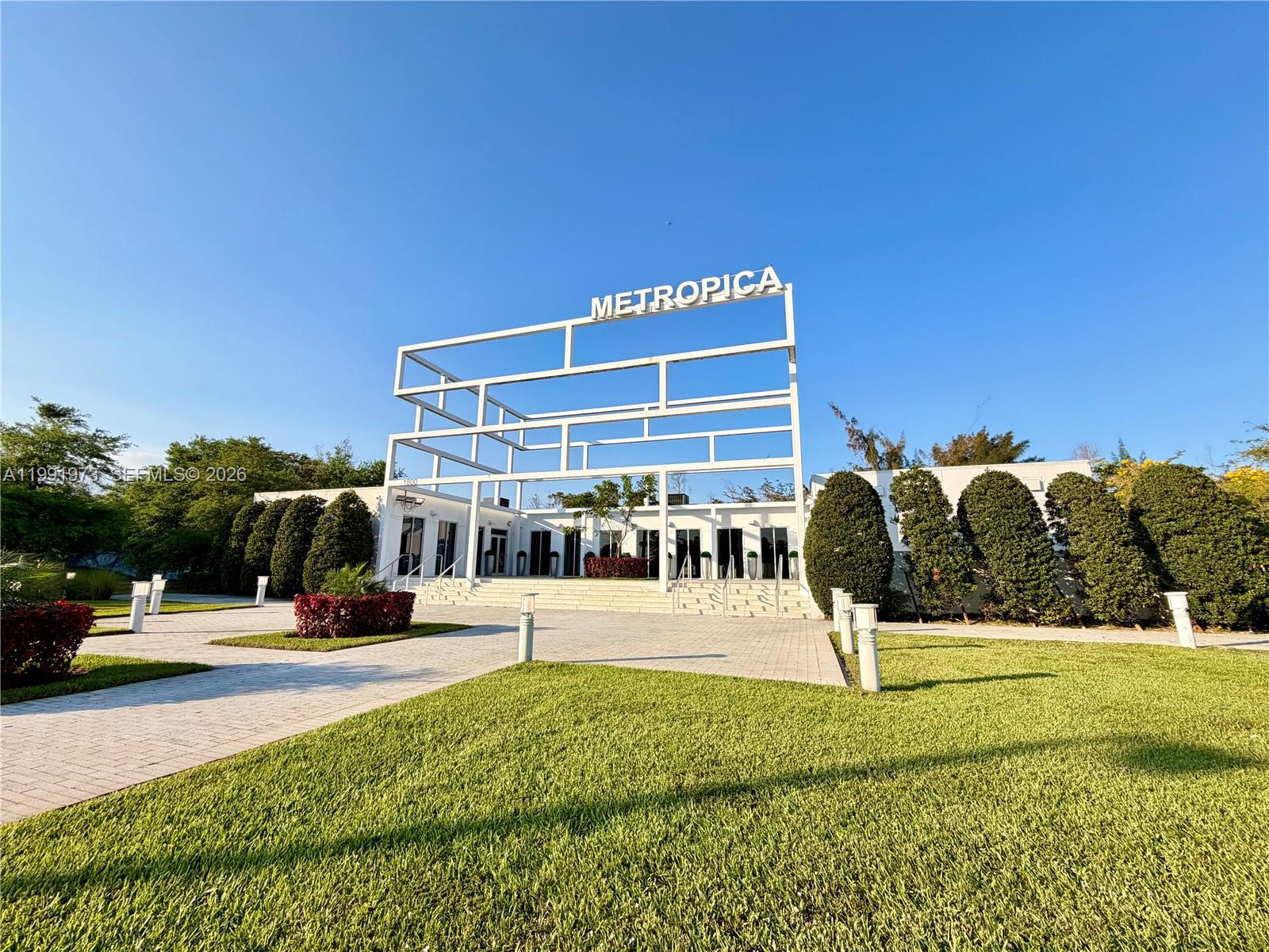 A white modern structure with the word Metropica stands above a building entrance — 2000 metropica way # 2208, Sunrise FL 33323, SUNRISE, FL