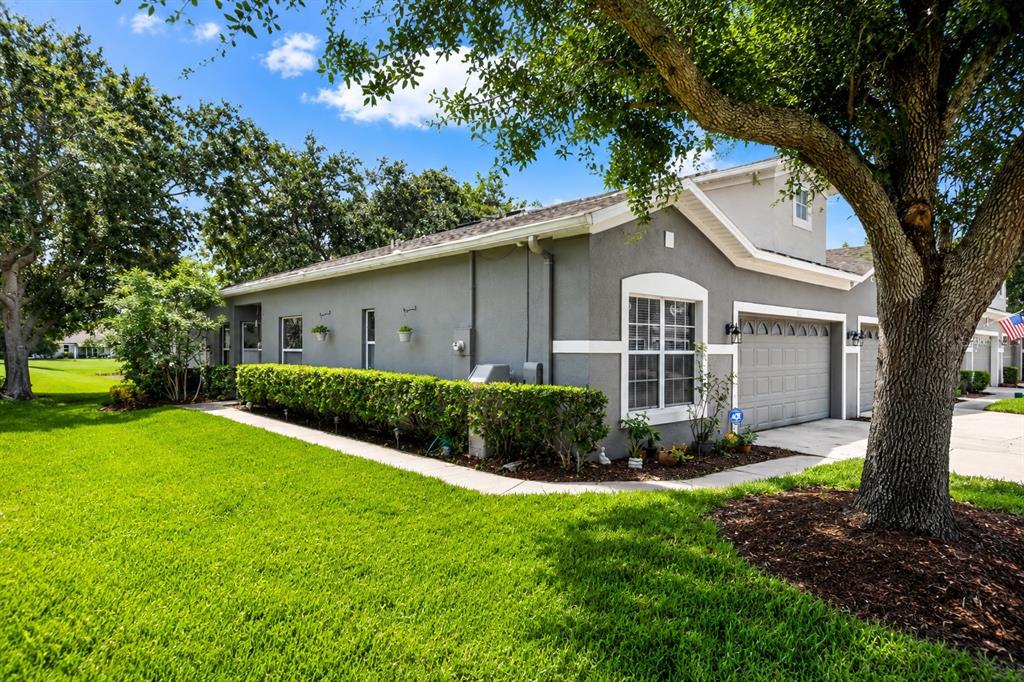 A gray single-story house with a two-car garage sits on a lawn with trees — 1121 TRAVERTINE TERRACE, SANFORD, FL