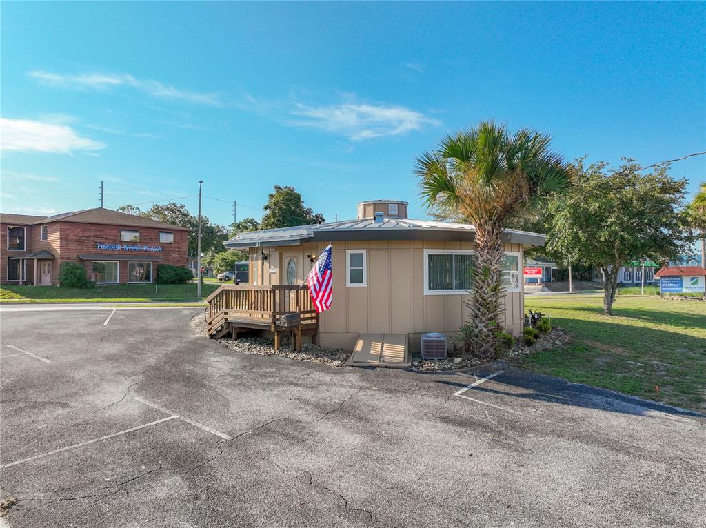 A small, tan, circular building with a wooden deck and an American flag — 811 S BAY STREET, EUSTIS, FL