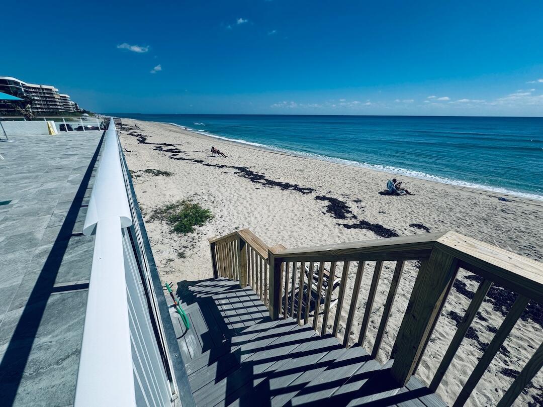 A wooden staircase leads from a tiled patio down to a sandy beach and ocean — 3450 S Ocean Boulevard # 5030, Palm Beach FL 33480, PALM BEACH, FL