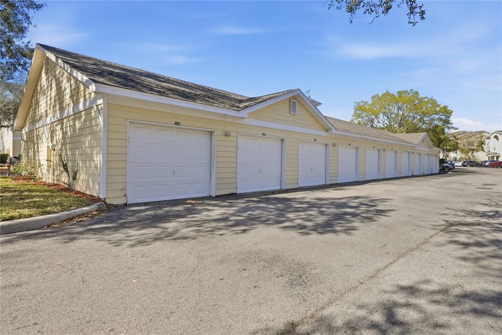 A row of detached garages with light yellow siding and white doors under a roof — 18311 BRIDLE CLUB DRIVE, TAMPA, FL
