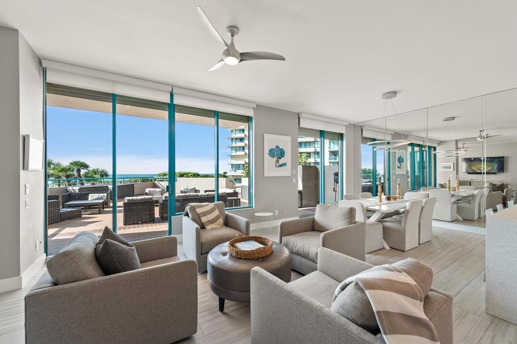 A modern living and dining area with floor-to-ceiling windows overlooking a balcony and ocean — 1560 GULF BOULEVARD UNIT 304, CLEARWATER, FL