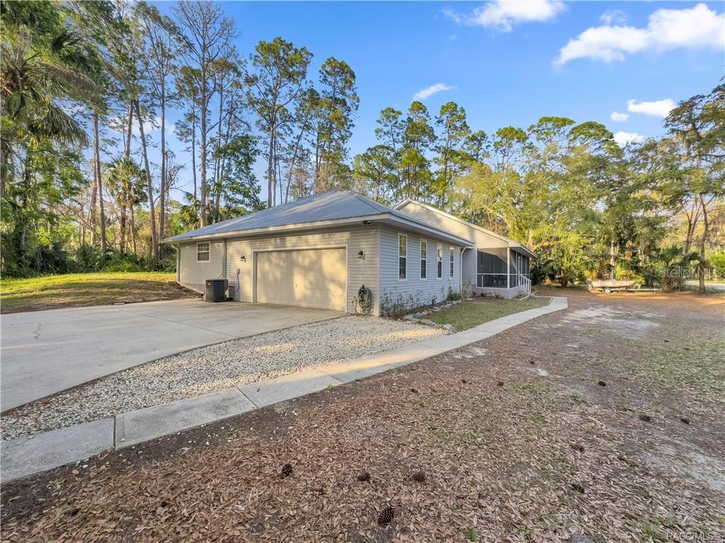 A light gray house with a metal roof, two-car garage, and a screened-in back porch — 10 PATRICIA ROAD, YANKEETOWN, FL