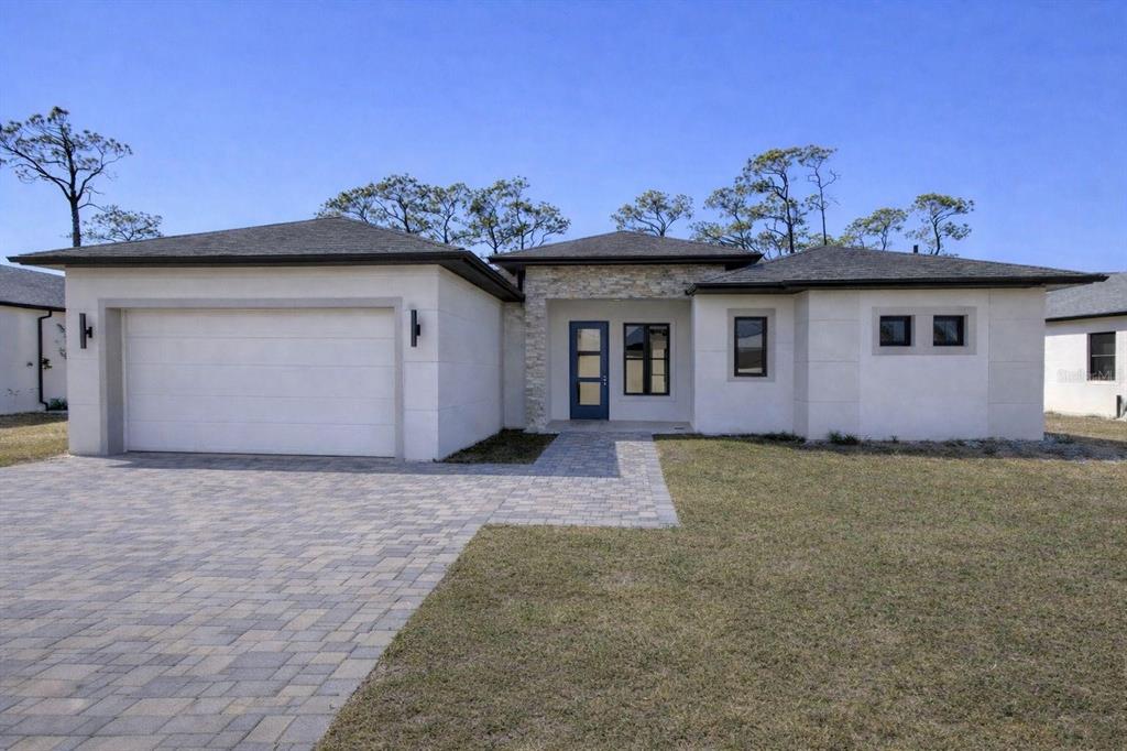 A single-story house with a white stucco exterior, stone accents, and a paved driveway — 1097 CORNELIUS BOULEVARD, PORT CHARLOTTE, FL