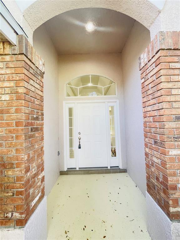 A front entryway features a white door with sidelights, an arched transom, and brick columns — 1738 GOLFVIEW DRIVE, KISSIMMEE, FL
