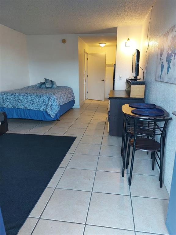 A studio apartment features a bed, a small dining table, and tile flooring — 43420 HIGHWAY 27 UNIT 157, DAVENPORT, FL
