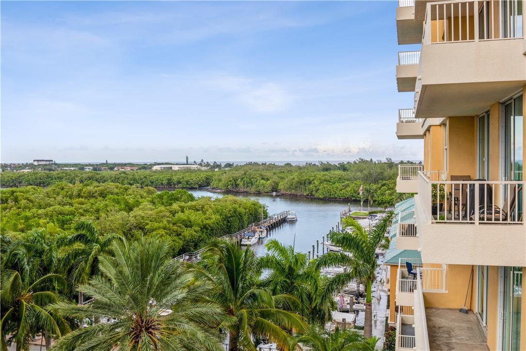An elevated view shows a balcony overlooking a marina, dense mangroves, and the distant ocean — 625 Casa Loma Boulevard # 705, Boynton Beach FL 33435, BOYNTON BEACH, FL
