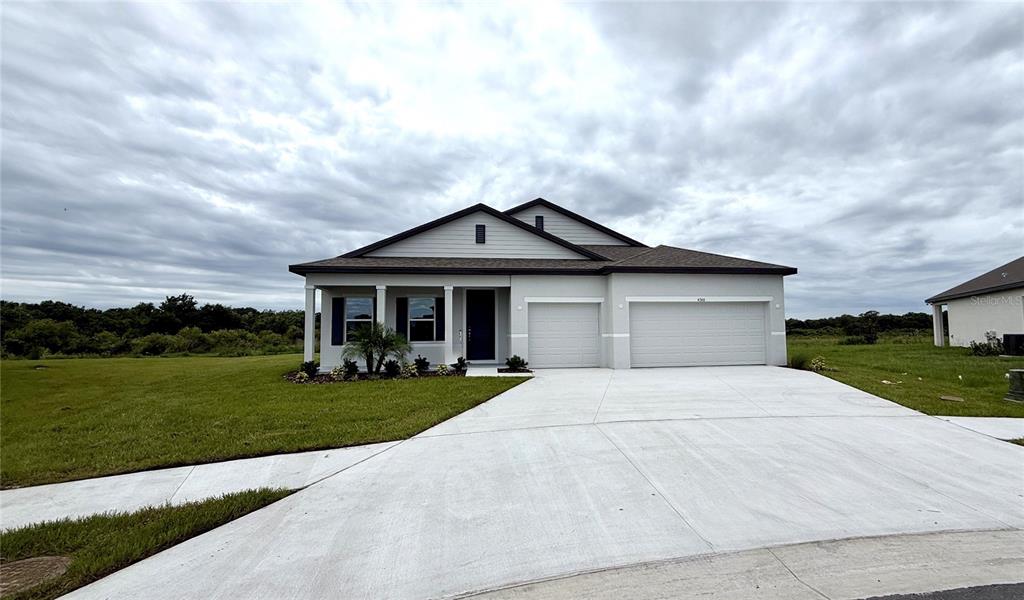 A single-story suburban house features a two-car garage, a covered entryway, and a concrete driveway — 4366 WINESAP WAY, LAKELAND, FL