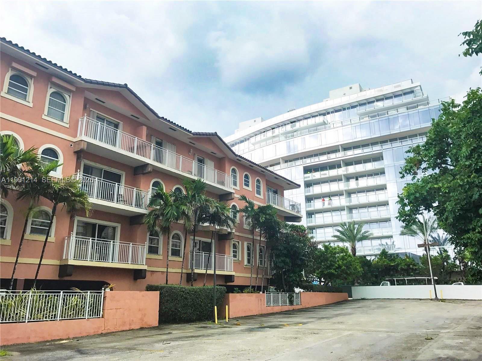 A low-rise pink apartment building stands next to a modern glass high-rise structure — 9008 Collins Ave # 402, Surfside FL 33154, SURFSIDE, FL