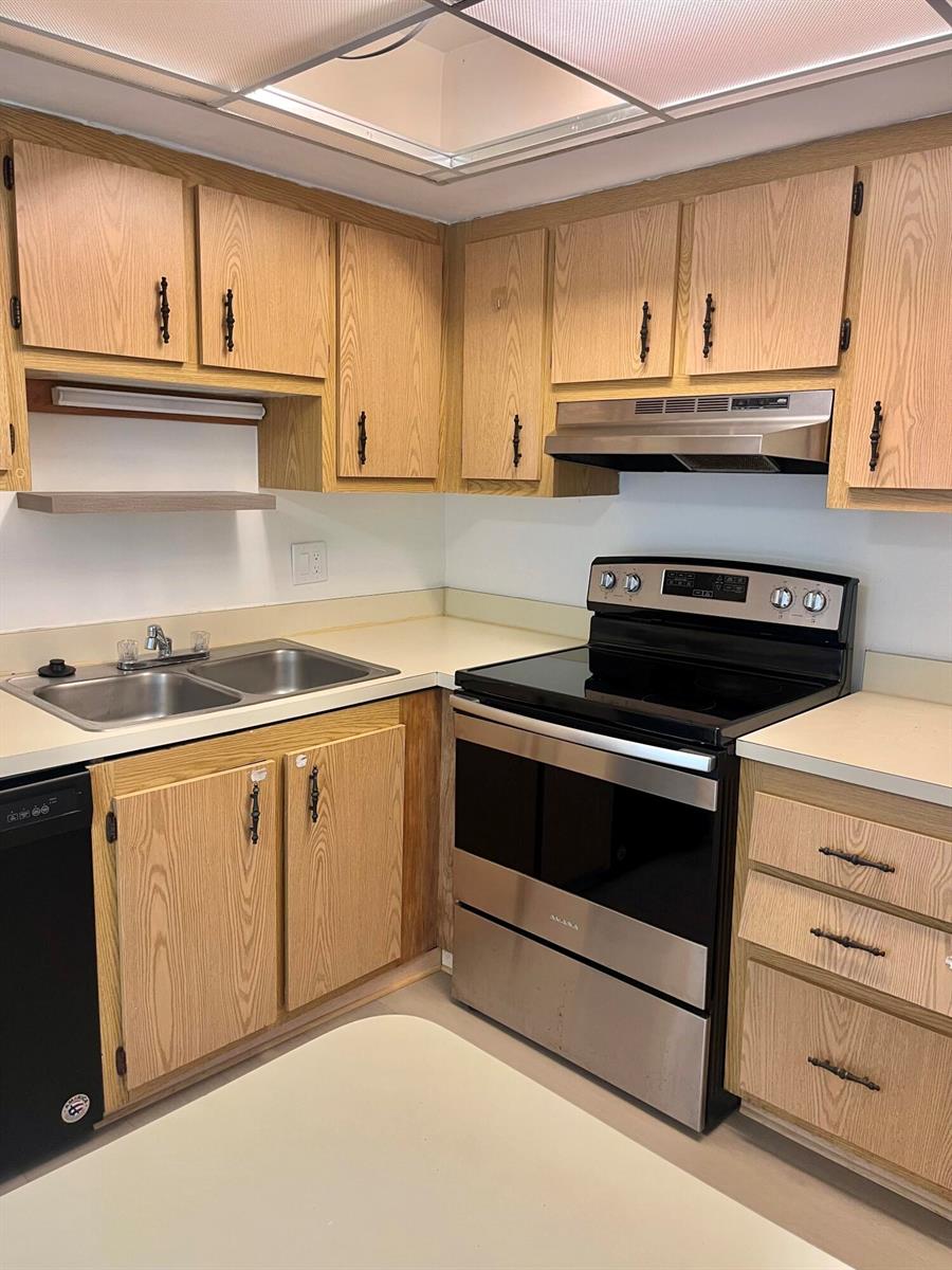 A kitchen features oak cabinets, laminate countertops, and stainless steel appliances — 4243 Oak Terrace Drive # 4243, FL 33463, FL