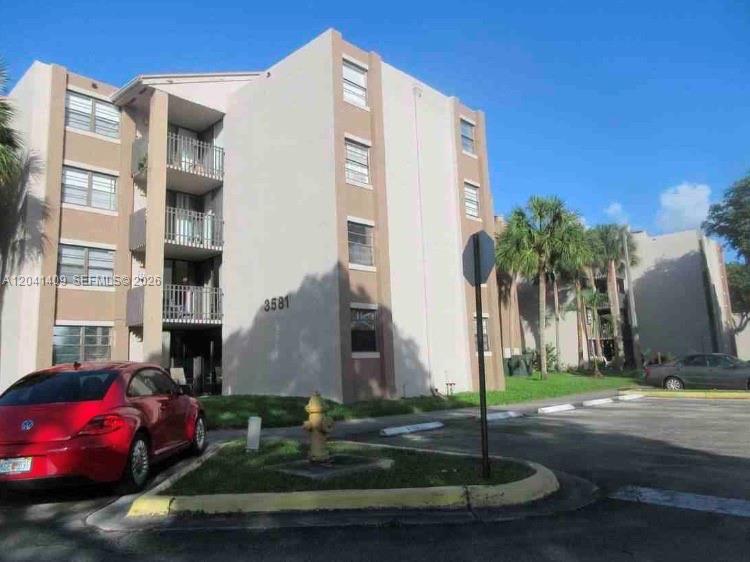 A multi-story apartment building with a red car parked in front of it — 3601 SW 117th Ave # 301, Miami FL 33175, MIAMI, FL