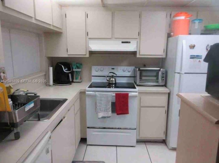 A kitchen with white cabinets, white appliances, a stainless steel sink, and tiled flooring — 3601 SW 117th Ave # 301, Miami FL 33175, MIAMI, FL