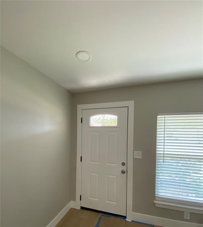A room with light gray walls, a white door, and a window with closed blinds — 10005 N 29TH STREET, TAMPA, FL