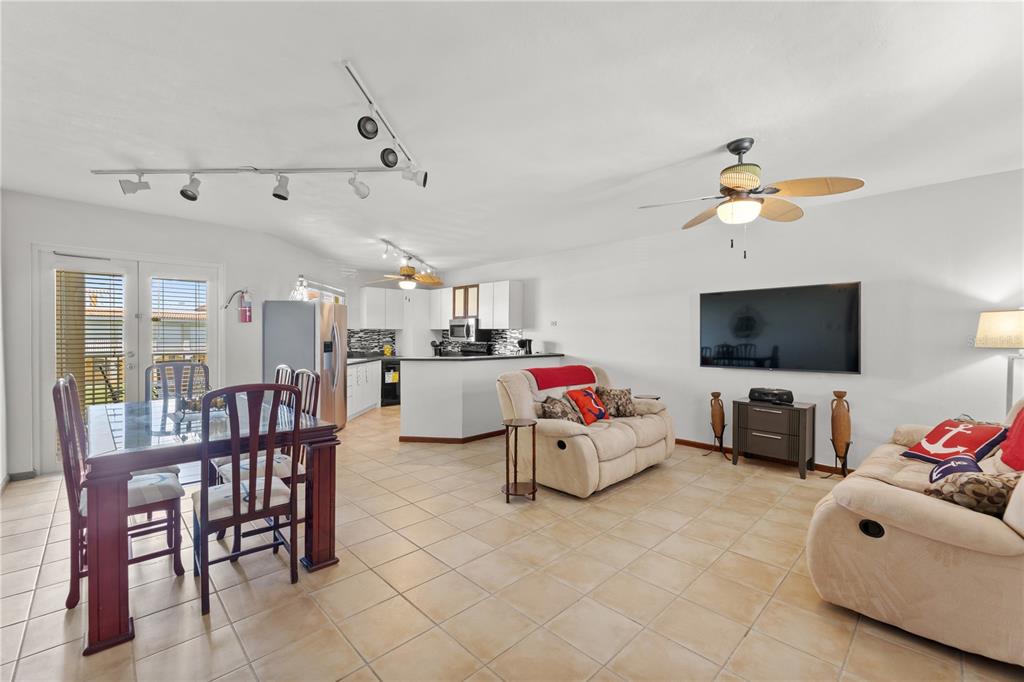 An open-concept living and dining area with tile floors, a kitchen, and a ceiling fan — 190 CANDELERO DRIVE UNIT 9247, HUMACAO, PR