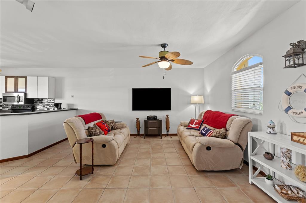 A living room features two beige sofas, a television, and tile flooring — 190 CANDELERO DRIVE UNIT 9247, HUMACAO, PR