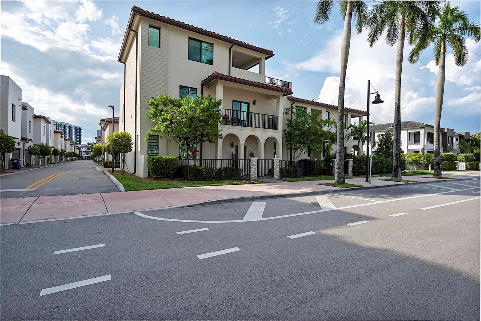 A three-story townhouse with a balcony and arched entryway sits along a paved street — 8321 Central Park Boulevard, Doral FL 33166, DORAL, FL
