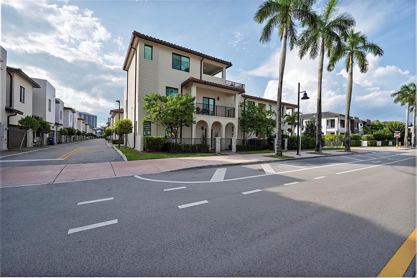 A three-story townhouse with a balcony and arched entryway sits on a paved street — 8321 Central Park Boulevard, Doral FL 33166, DORAL, FL