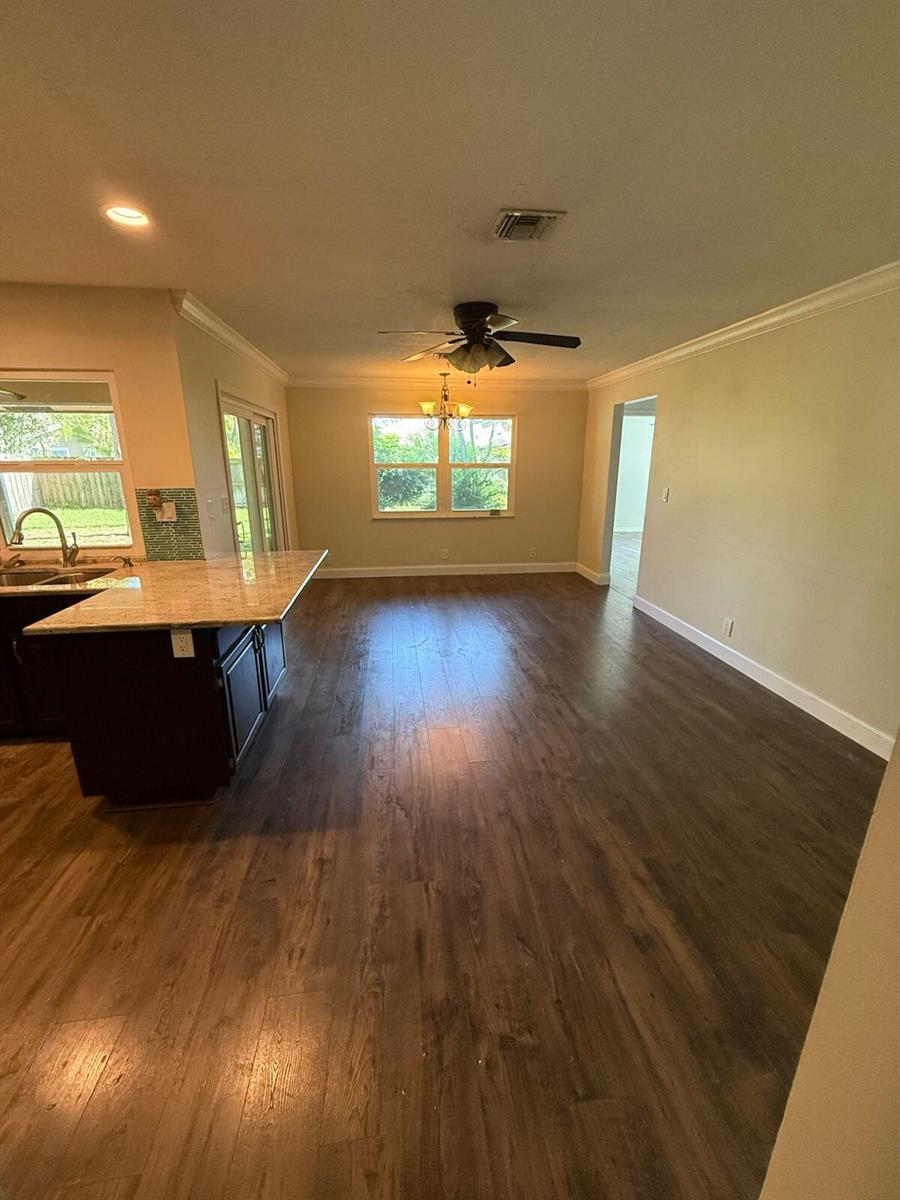 A kitchen with a granite island and dark cabinets opens into a spacious dining area — 13584 Exotic lane, Wellington FL 33514, WELLINGTON, FL