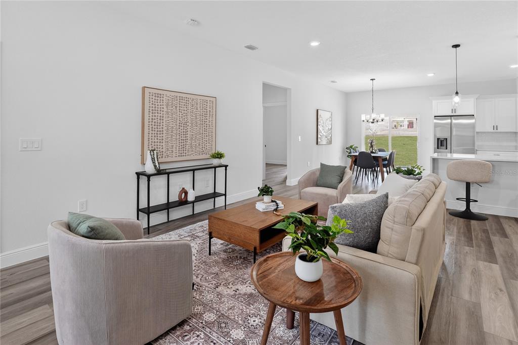 A living room with light wood floors, a beige sofa, two armchairs, and a coffee table — 1933 W OLIVER DRIVE, CITRUS SPRINGS, FL