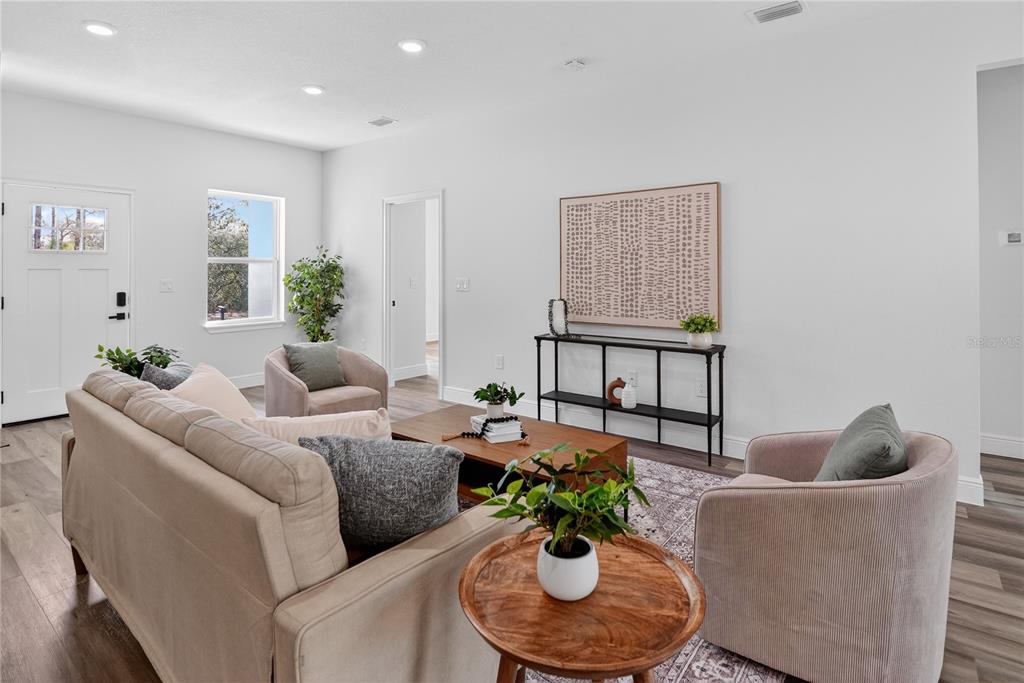 A living room features light wood flooring, a beige sofa, two armchairs, and a console table — 1933 W OLIVER DRIVE, CITRUS SPRINGS, FL