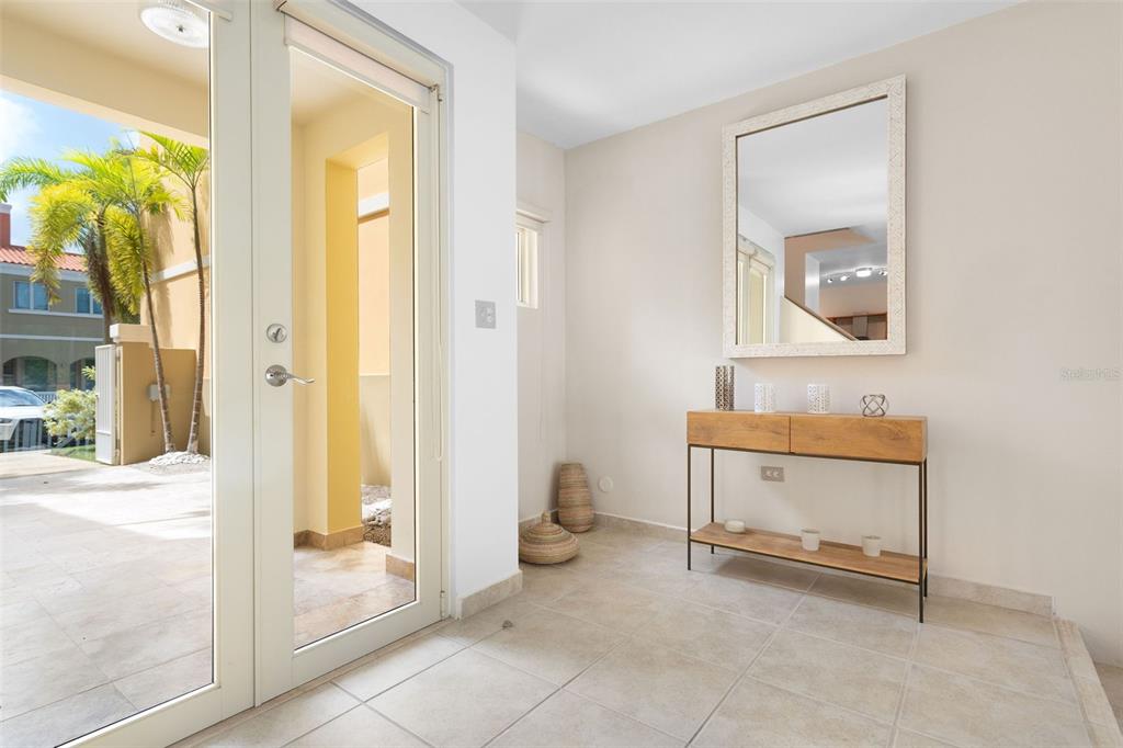 An entryway features tile flooring, a console table with a mirror, and a glass door — 90 CANDELERO DRIVE UNIT 78, HUMACAO, PR